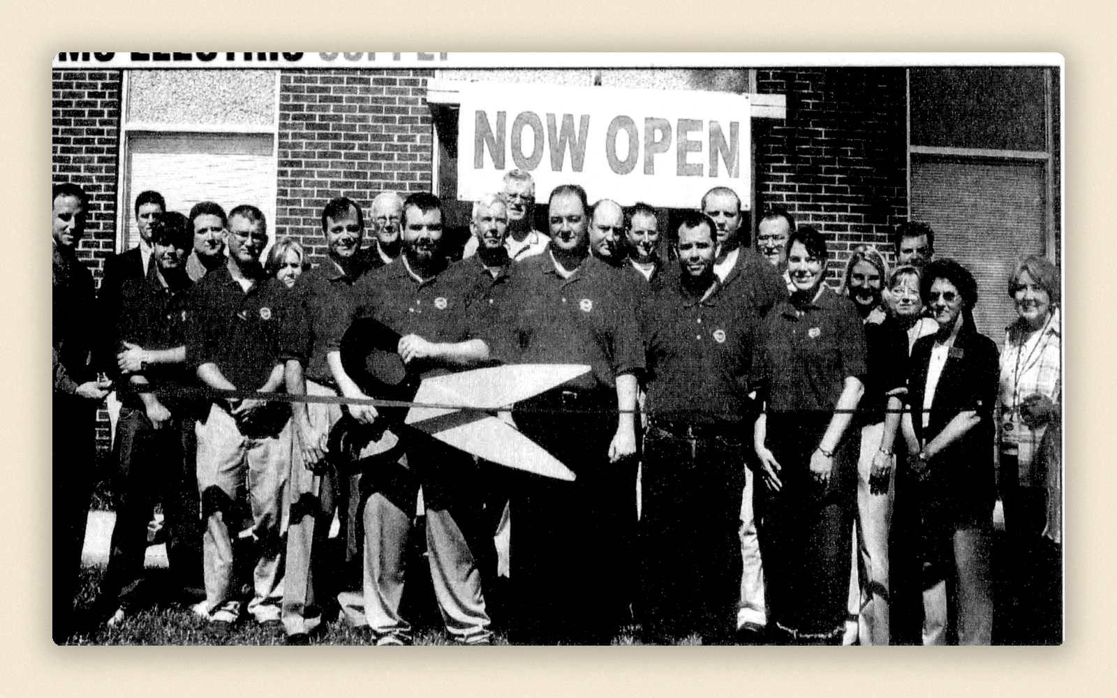 Historic ribbon-cutting photograph marking continued company growth